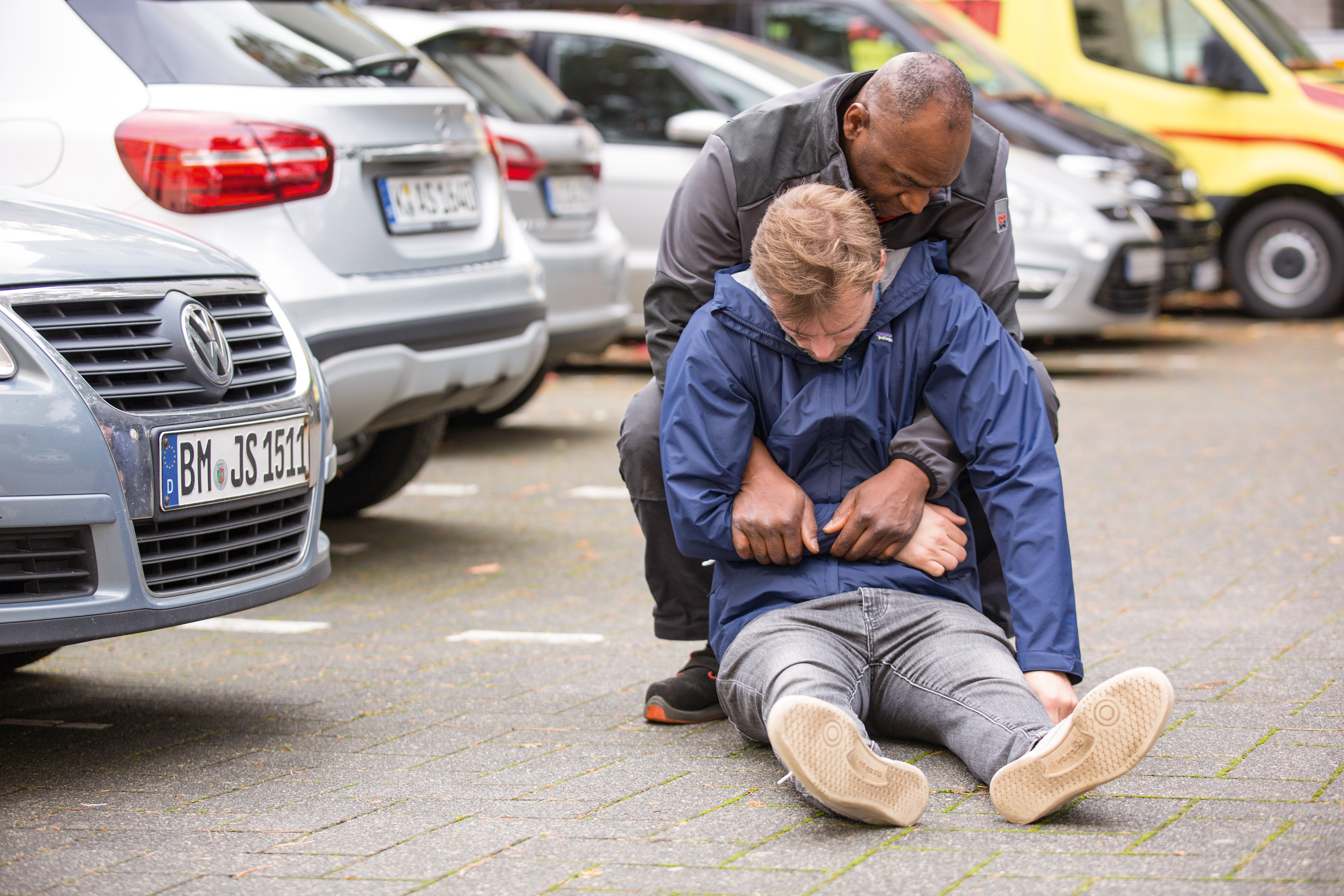 Erste_Hilfe-1742.jpg Ein Mann leistet einem anderen Mann Erste-Hilfe und zieht ihn mit dem Rettungsgriff aus einer Gefahrensituation.